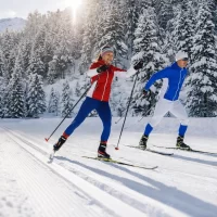 Cross-country ski coaching session with skaters training on a groomed trail in a winter forest
